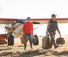 Angler carrying the Fishpond Green River Gear Bag using the rope haul handle—durable outdoor gear bag designed for convenience.