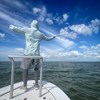 Angler casting a fly rod from a boat while wearing a Rep Your Water Flolite Sun Hoody in clearwater