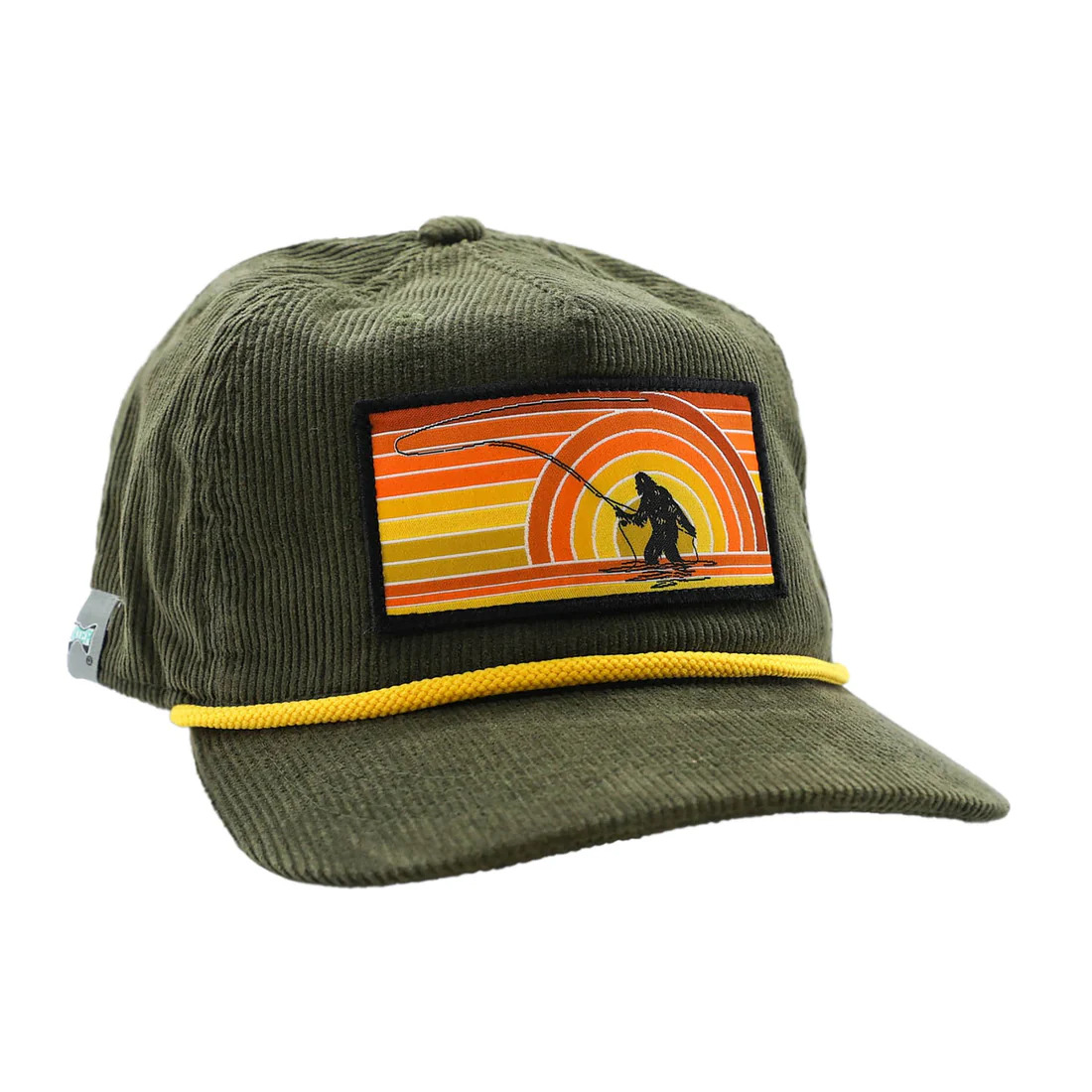 A green corduroy hat with sasquatch casting in front of a colorful sunset