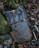 Simms Headwaters Backpack next to fly fishing rod on rocks.