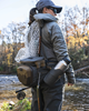 Woman fishing while wearing Simms Headwaters Hip Pack with net and water bottle holder.