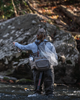 Rear shot of woman casting while wearing Simms Headwaters Hip Pack.