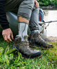 Angler putting on Simms Neoprene Wading Socks.